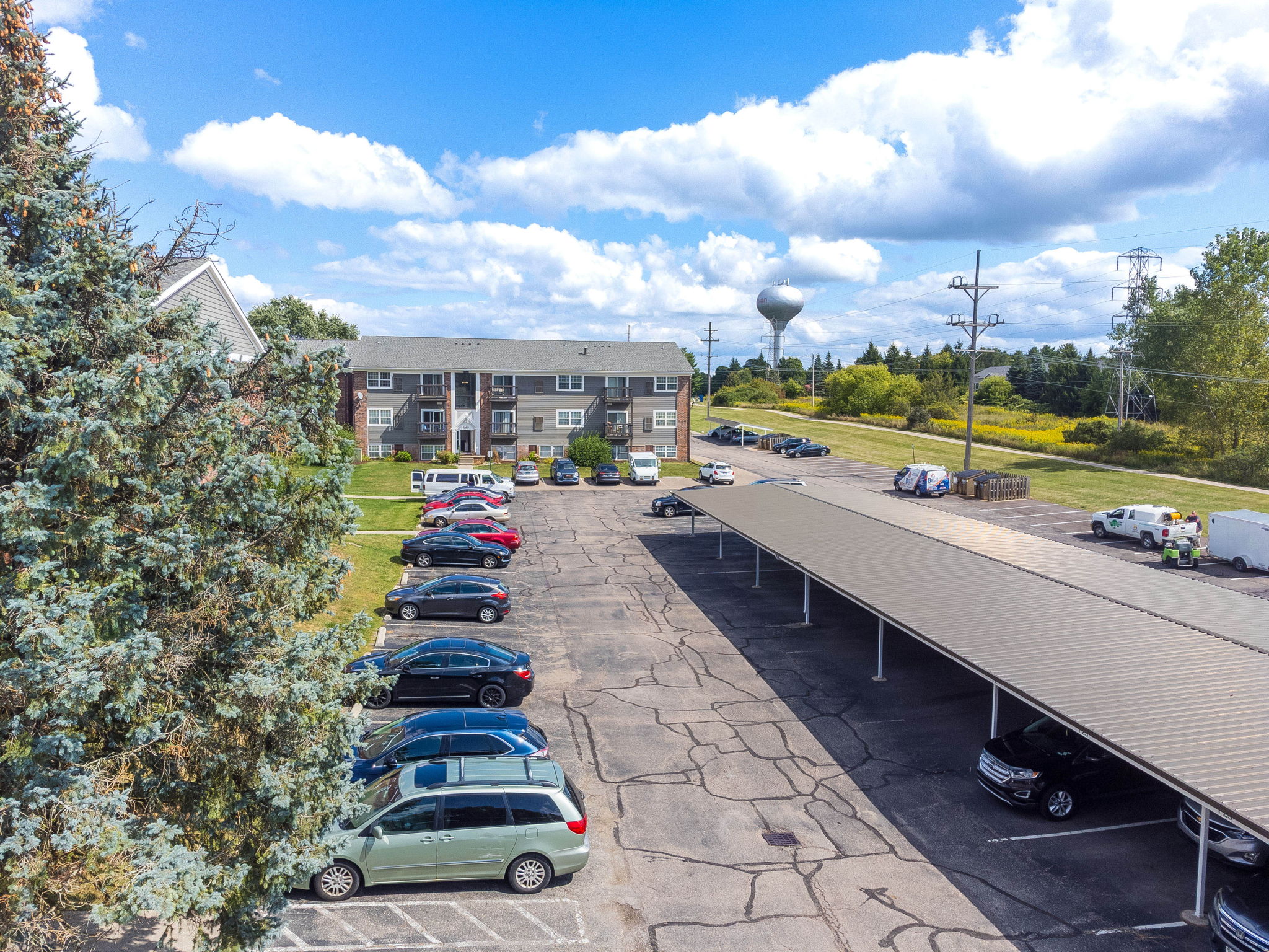 A parking lot with cars and a building in the background.